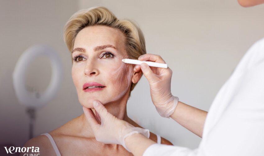Closeup of mature woman with face contour lines during anti-aging consultation at beauty clinic. Dermatologist preparing for cosmetic facelift procedure. Skincare, rejuvenation and aesthetic treatment